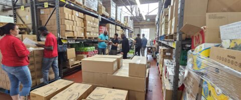 A warehouse full of boxes and North York Harvest Food Bank staff packing orders.