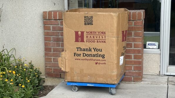 An empty donation box for North York Harvest Food Bank sits outside.