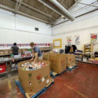 People sort through food items in a food bank warehouse.