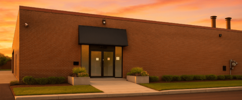A rendering of a large warehouse with a sunset in the background.