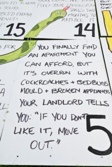 A hand-drawn sign that describes someone finally getting an apartment but it's full of pests and mold. The landlord says if they don't like it, they can move out.