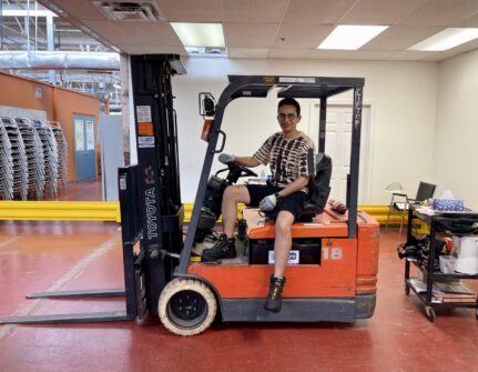 A man sits on a forklift at North York Harvest Food Bank.
