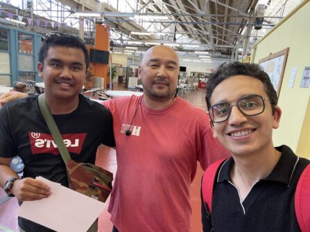Three people with their arms around one another smile for a selfie at North York Harvest Food Bank.