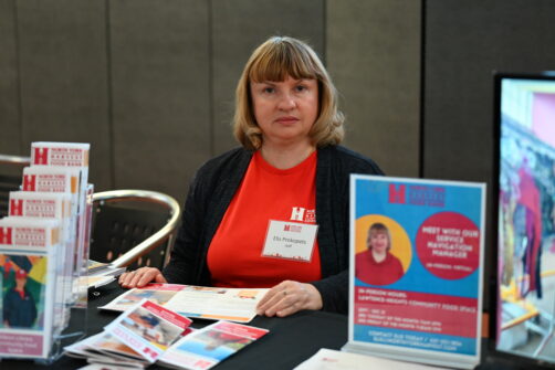 A woman sits at an information booth for North York Harvest Food Bank.