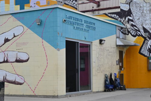 Lawrence Heights Community Food Centre is seen from the outside, the exterior is covered in a colourful mural.